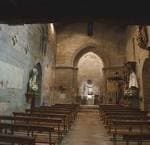 Interior de la Iglesia de Santa María de Castrelos con bancos de madera y altar