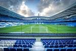 Interior del Estadio de Riazor con el campo de fútbol y las gradas azules