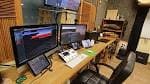 Estudio de producción o edición con múltiples monitores y equipo técnico