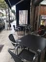 Terraza exterior con mesas y sillas en la acera de Restaurante El Estribo