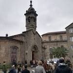 Fachada principal de la Iglesia de San Fiz de Solovio con gente en la entrada