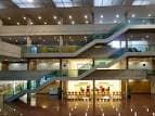 Amplio atrio interior de la Facultad de Derecho con escaleras y múltiples niveles