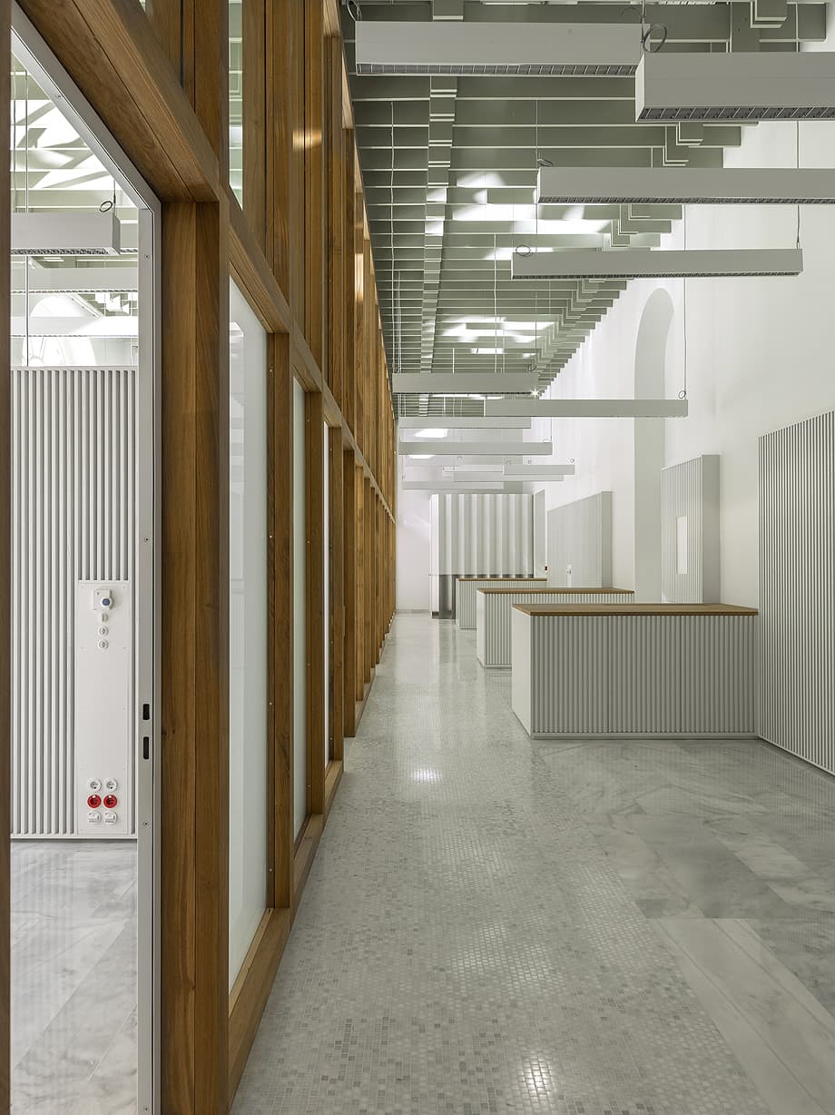 Pasillo interior de galería con estructura de madera y suelo de hormigón