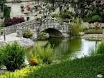 Puente de piedra y estanque en los jardines de Finca Batacos