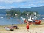 Vista de la Isla de San Simón desde la orilla, con barcas de pesca en primer plano