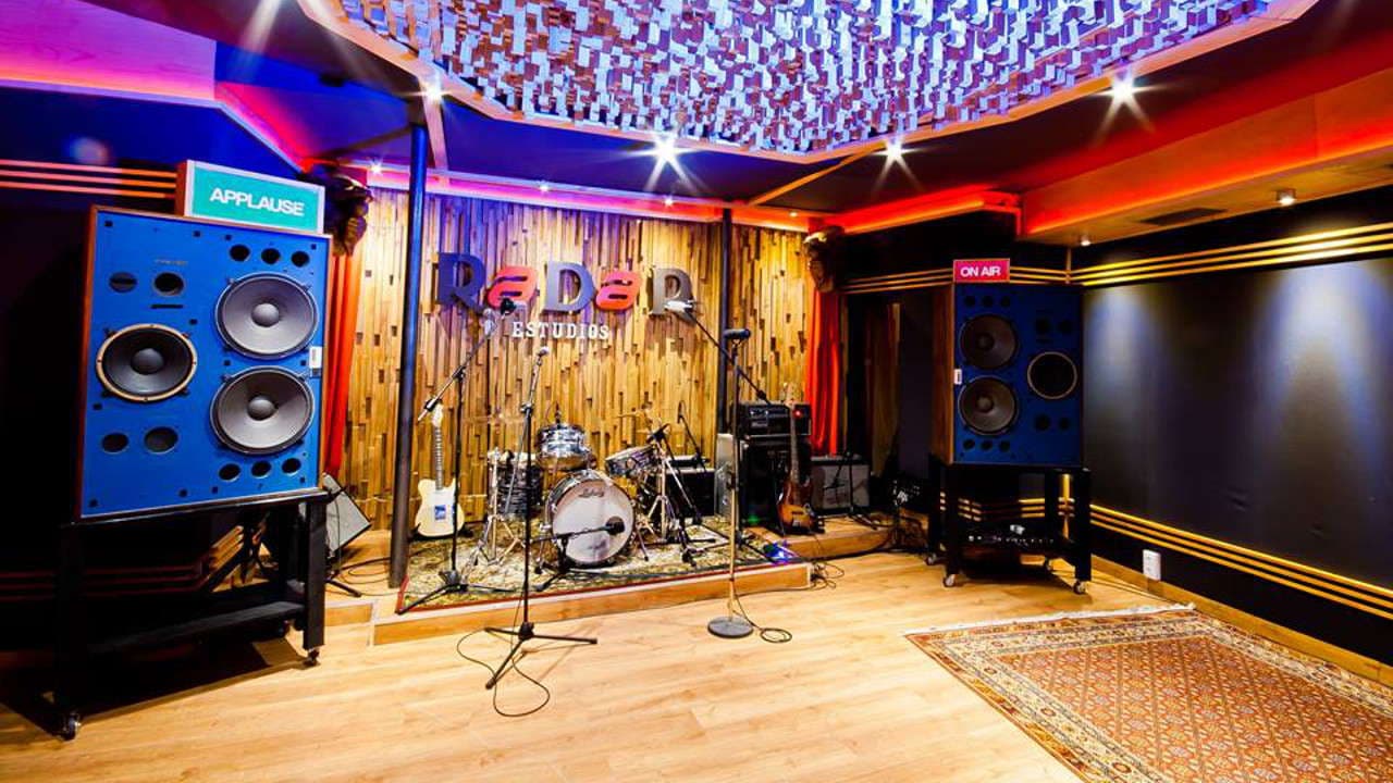 Sala de ensayo o escenario con batería e instrumentos