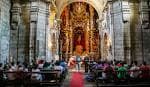 Interior de la Iglesia de la Merced de Conxo con el retablo principal y asistentes
