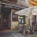 Fachada exterior de The Monk Pub con mesas y sombrillas en la terraza