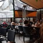 Terraza exterior de un café o restaurante con mesas y sombrillas