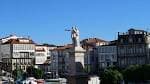 Estatua en la Praza dos Irmáns García Naveira con edificios al fondo