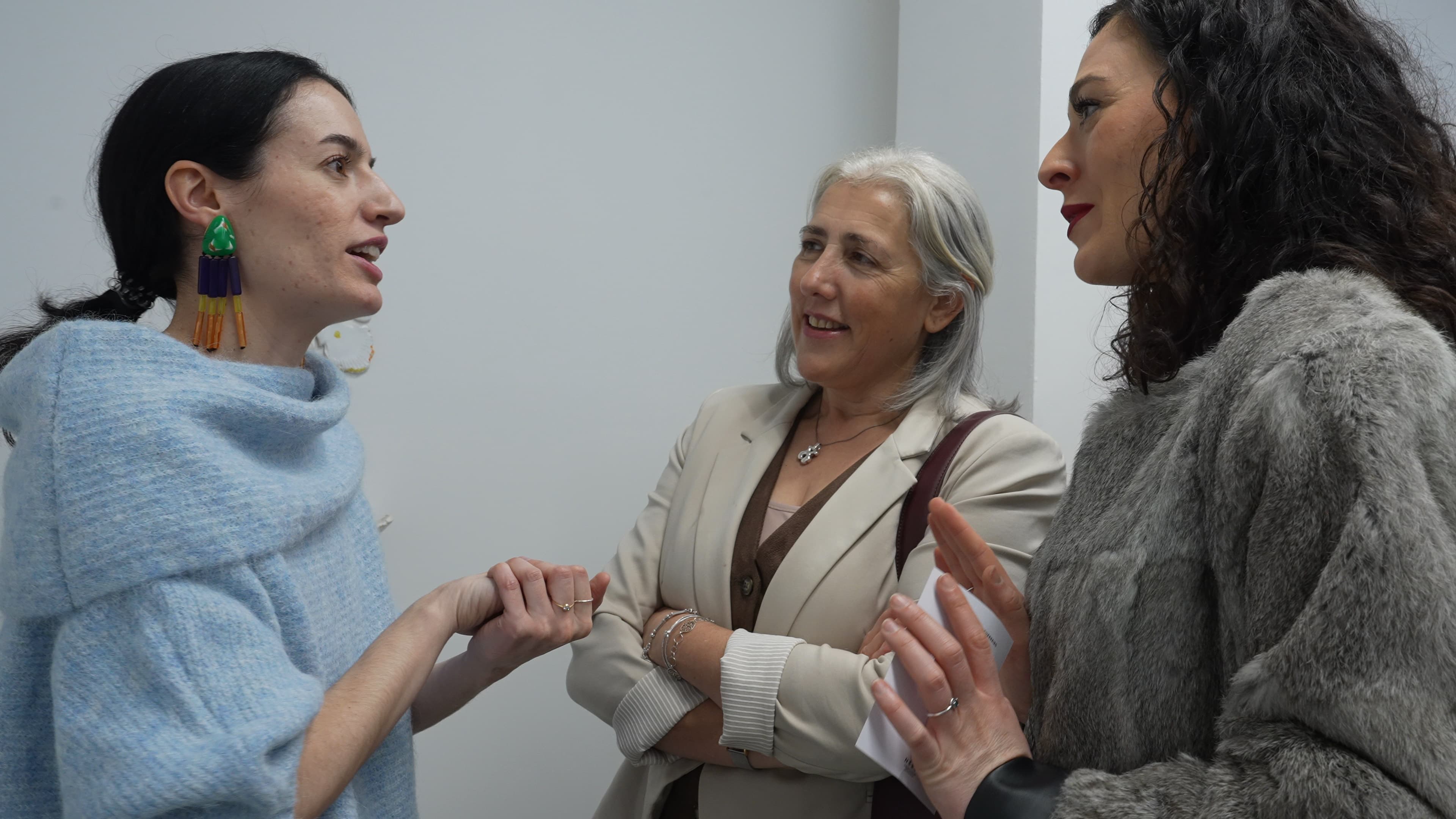 Asistentes conversando en el interior de la galería durante un evento