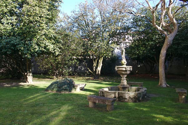 Jardín del Pazo de Amarante con fuente de piedra y vegetación