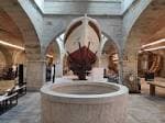 Gran sala del museo con un modelo de barco y una estructura circular de piedra