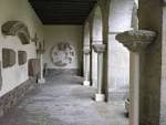 Pasillo interior del claustro con arcos y elementos arquitectónicos