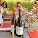 Grupo de personas disfrutando de una cata de vinos al aire libre en la bodega.