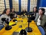 Grupo de personas en un estudio de radio con micrófonos y auriculares