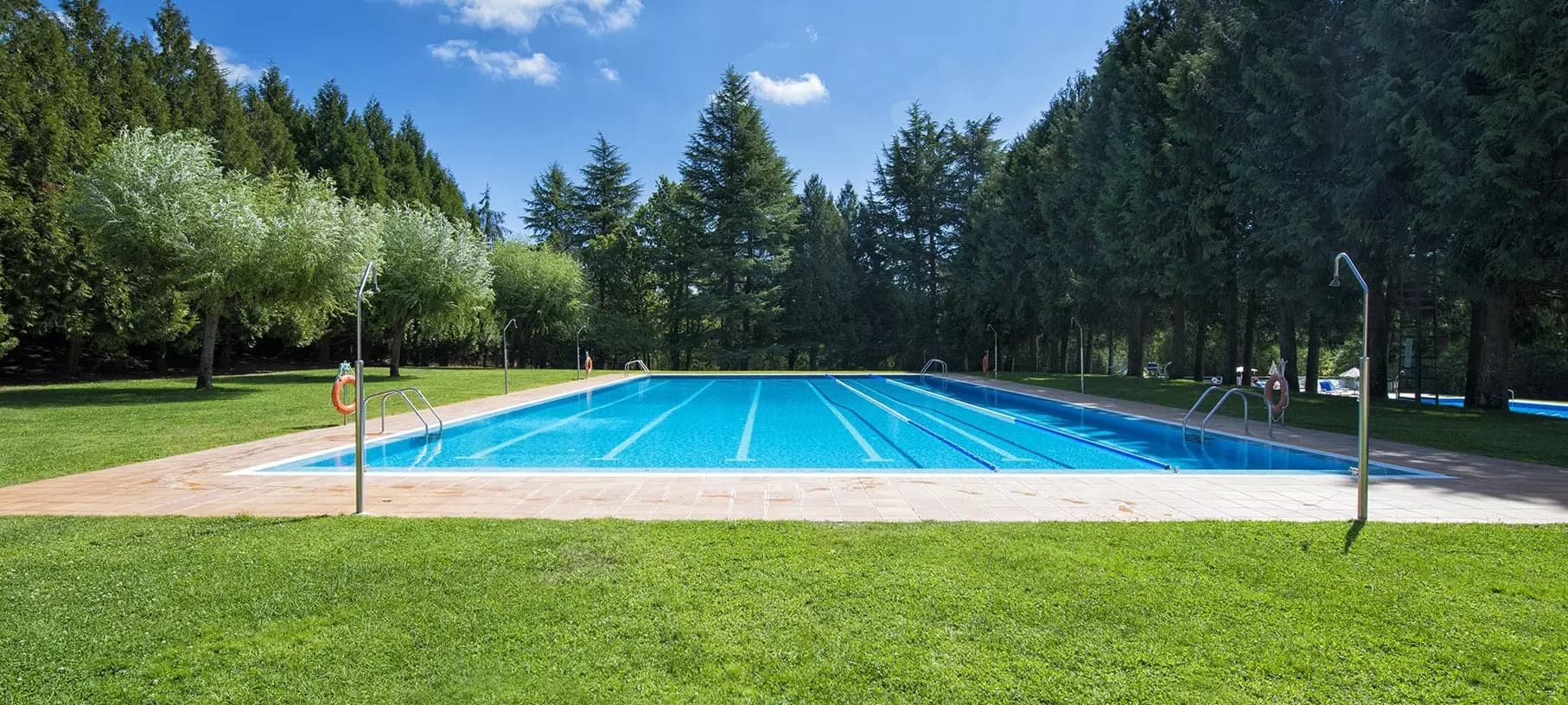 Piscina exterior del Club Santo Domingo rodeada de vegetación