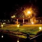 Jardín nocturno del hotel con iluminación cálida y un cenador, ideal para eventos.