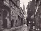 Antigua fotografía en blanco y negro de la Rúa do Vilar con la torre de la catedral visible.