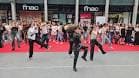 Grupo de personas bailando en un evento al aire libre frente a la entrada de Fnac A Coruña.