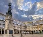 Estatua de María Pita en la plaza, rodeada de edificios con soportales