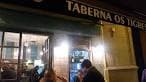 Fachada iluminada de la Taberna Os Tigres por la noche