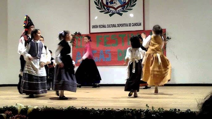Niños bailando danza gallega tradicional en un escenario en Vigo