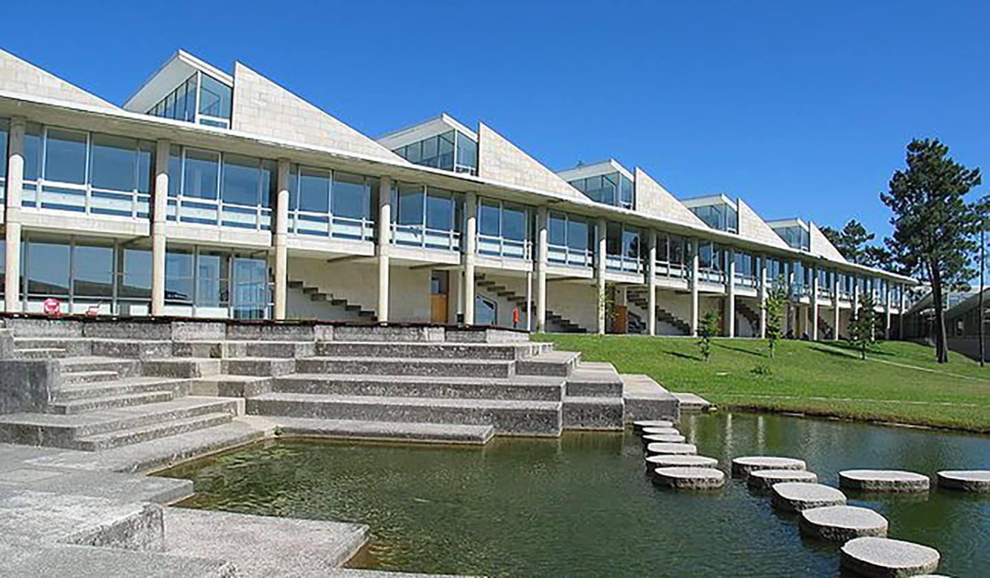 Vista exterior de la Facultad de Ciencias Empresariales y Turismo con estanque y escaleras