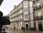 Fachada de la Sede Afundación Lugo en una calle urbana con balcones.