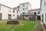 Patio interior del Pazo con fuente de piedra central y arquitectura tradicional