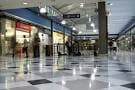 Pasillo interior del centro comercial con tiendas a los lados y suelo pulido