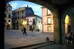 Perspectiva de la Praza da Constitución desde un arco, con la plaza al atardecer