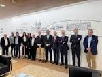 Grupo de personas en un salón del Club Financiero de Santiago con mural de la ciudad