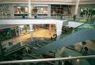 Interior del Centro Comercial Travesía con escaleras mecánicas y tiendas