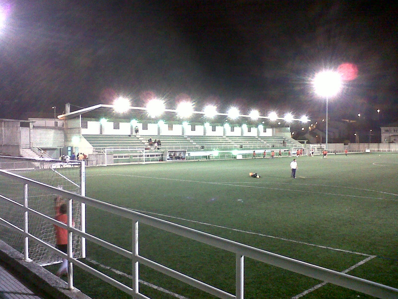 Vista nocturna del campo de fútbol municipal con iluminación