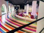 Interior moderno del Espacio Circus con suelo de rayas de colores y arcos