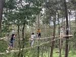Personas participando en un circuito de aventura entre los árboles del Parque Forestal de Beade