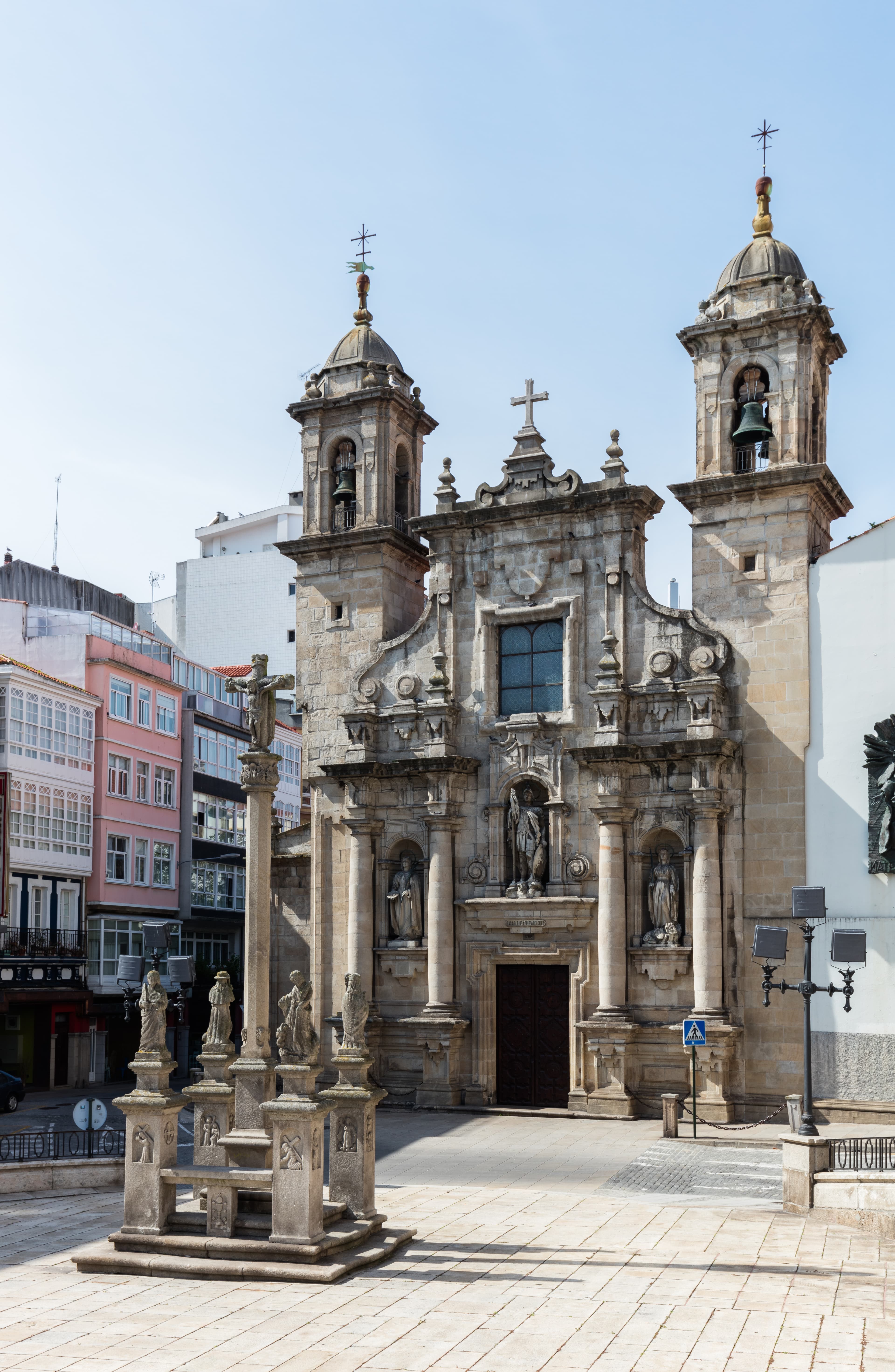 Vista exterior de la Iglesia de San Jorge con el cruceiro en primer plano