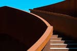 Detalle arquitectónico de las paredes curvas de acero corten y escaleras