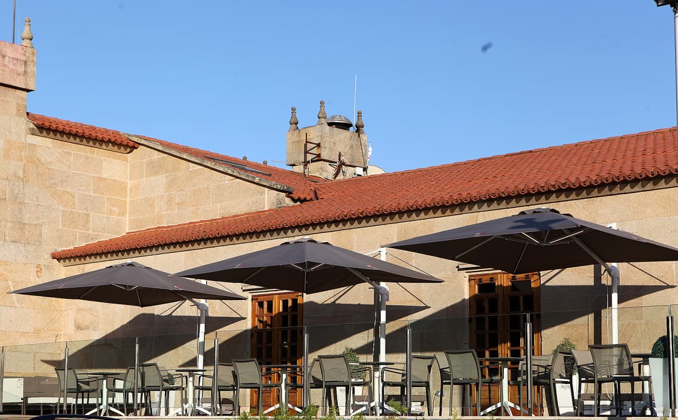 Terraza exterior del club con sombrillas y mesas