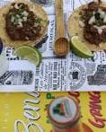 Tacos frescos con lima y bebida sobre mesa decorada