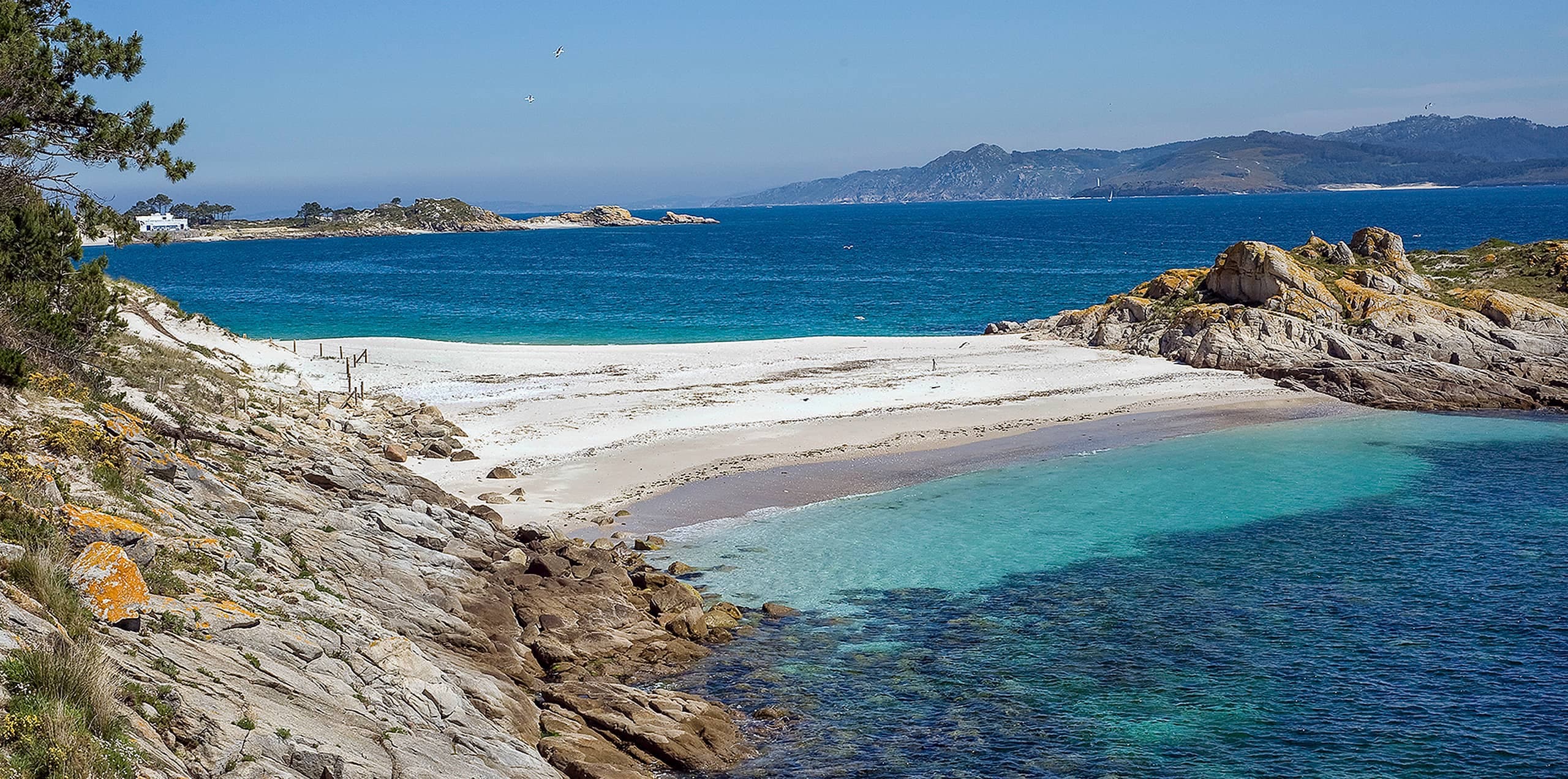 Cala rocosa con playa de arena y aguas claras en las Islas Cíes