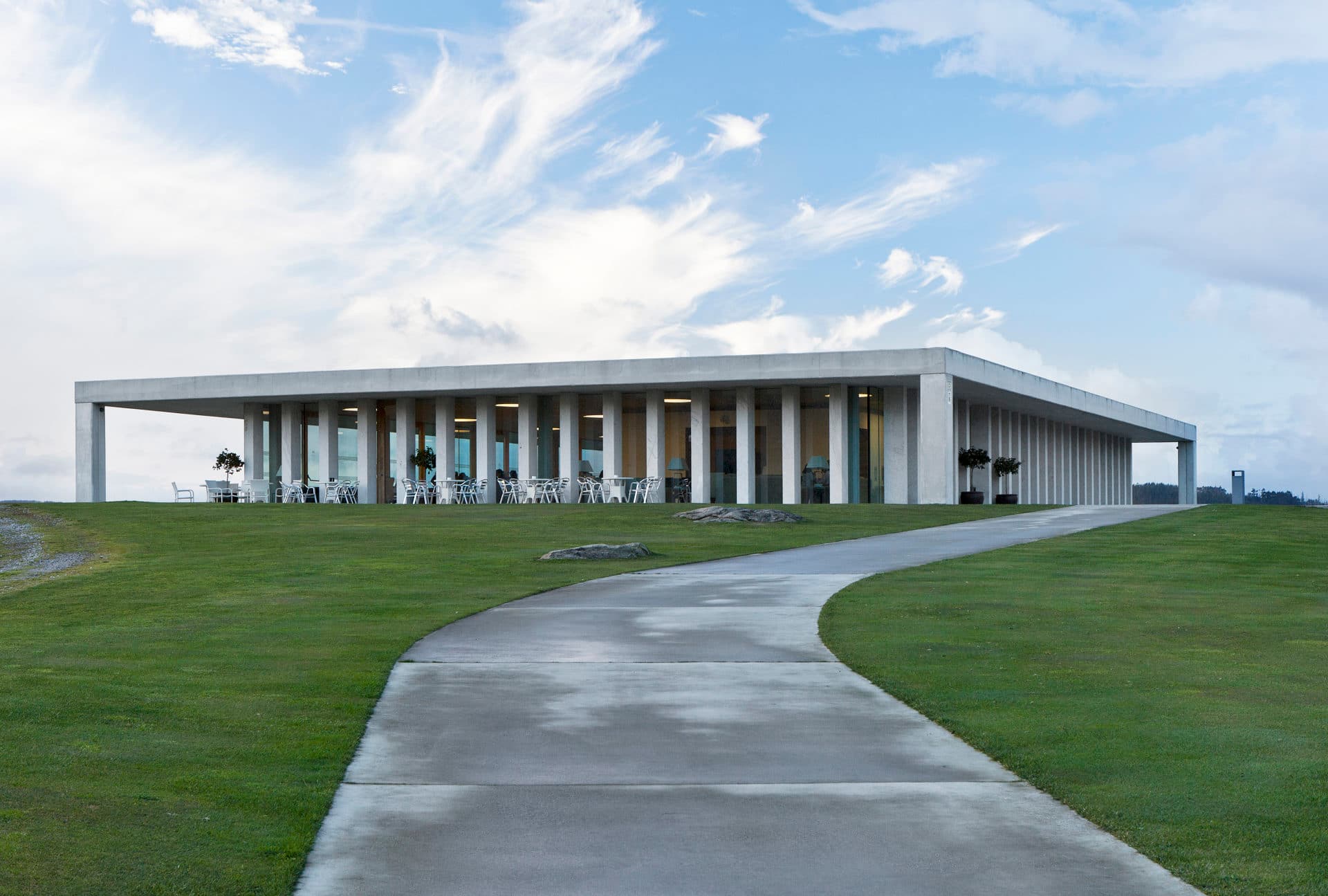 Vista frontal del edificio principal del Real Aeroclub con césped y camino