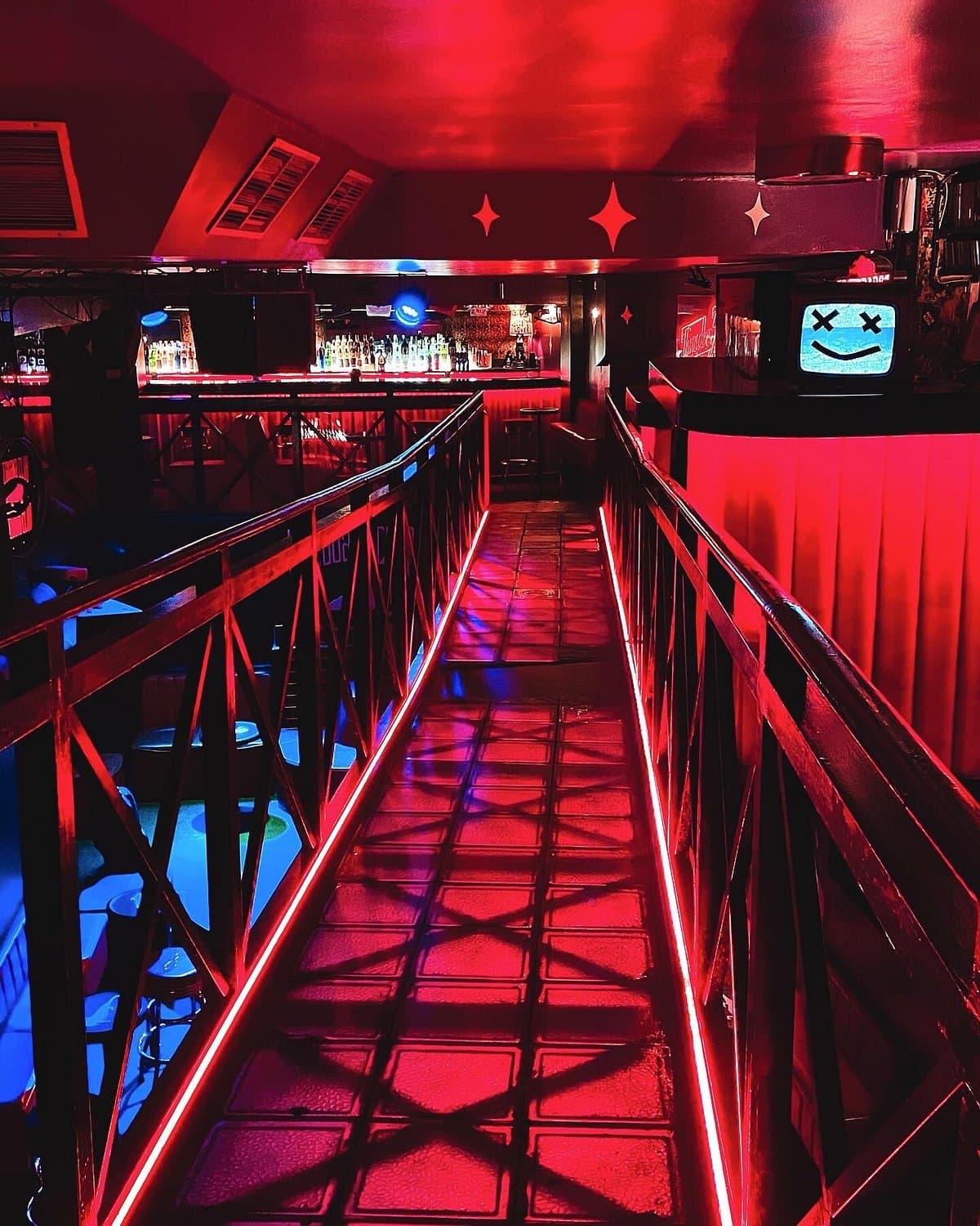 Interior del club con pasarela elevada y luces rojas